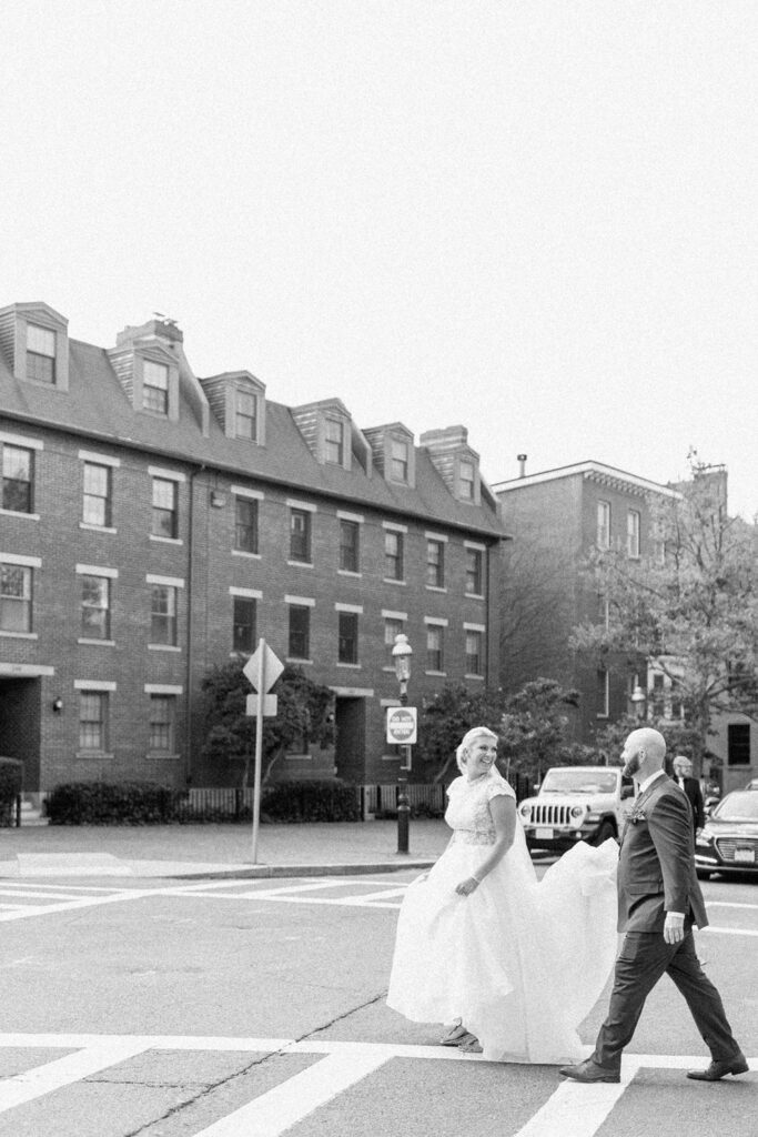 Black and white photo of bride and groom walking in the streets of Boston