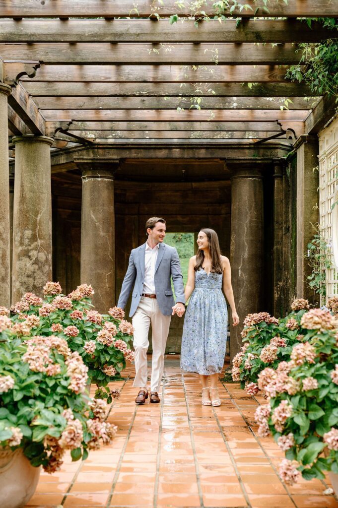 Couple walking hand in hand during estate engagement photos 