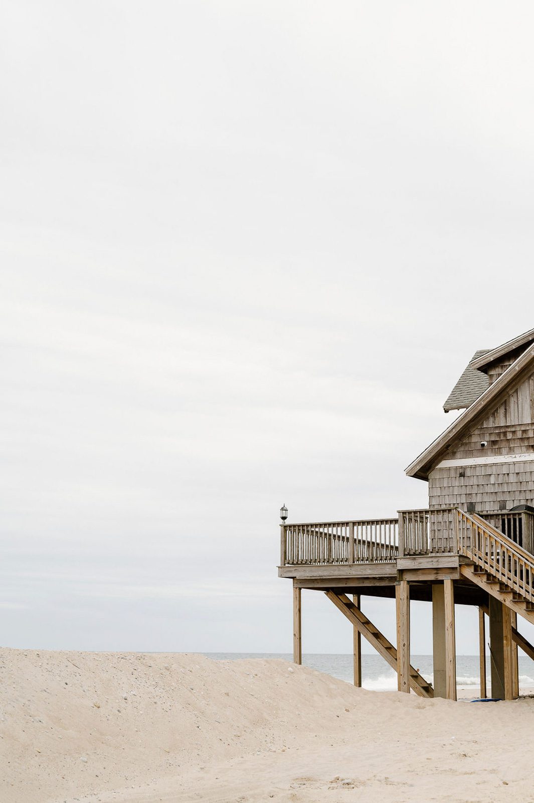 a cabin with the beach and ocean surrounding it.