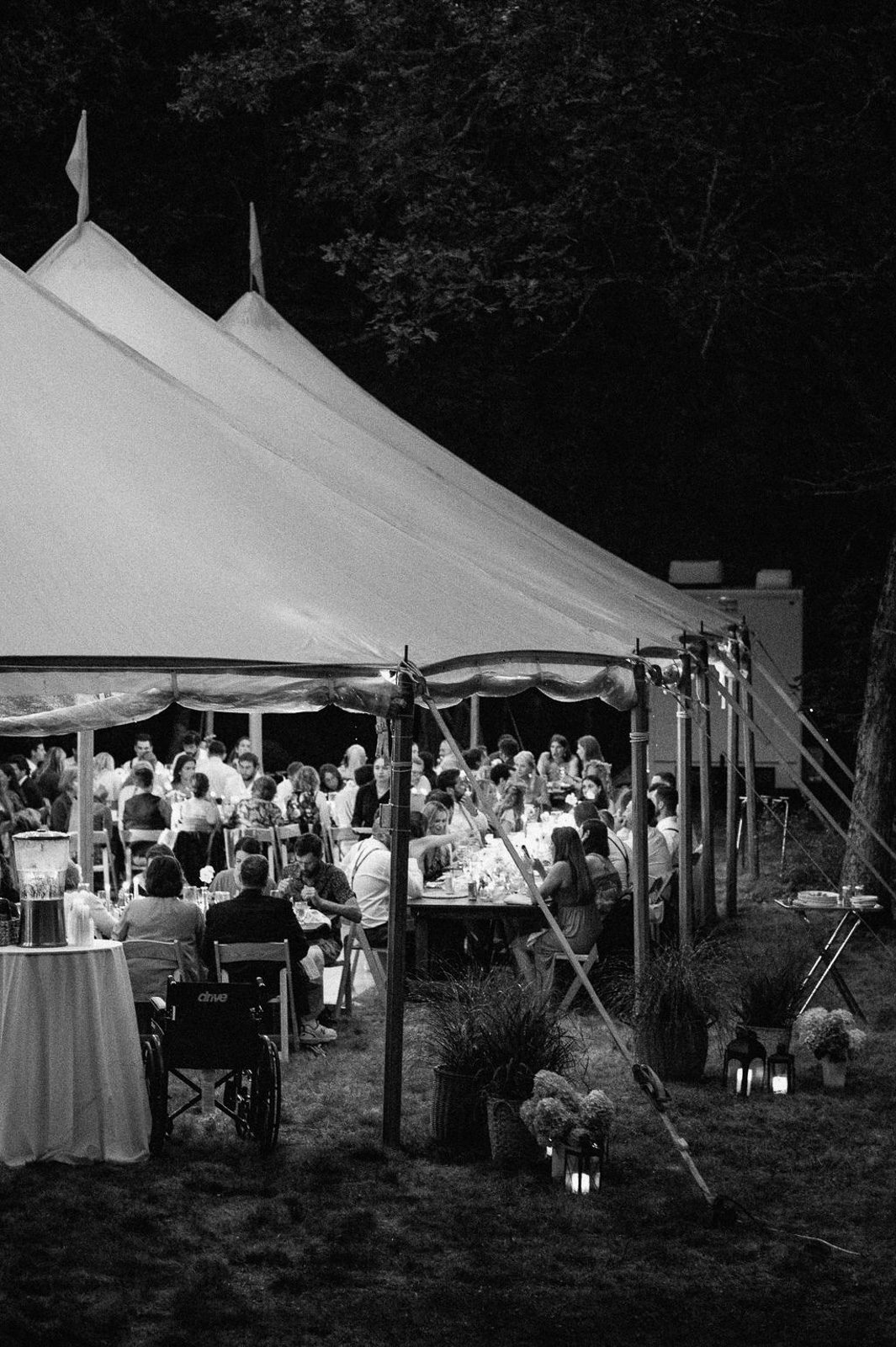 the wedding guests enjoying a meal under a covered tent, captured as part of the wedding day coverage.
