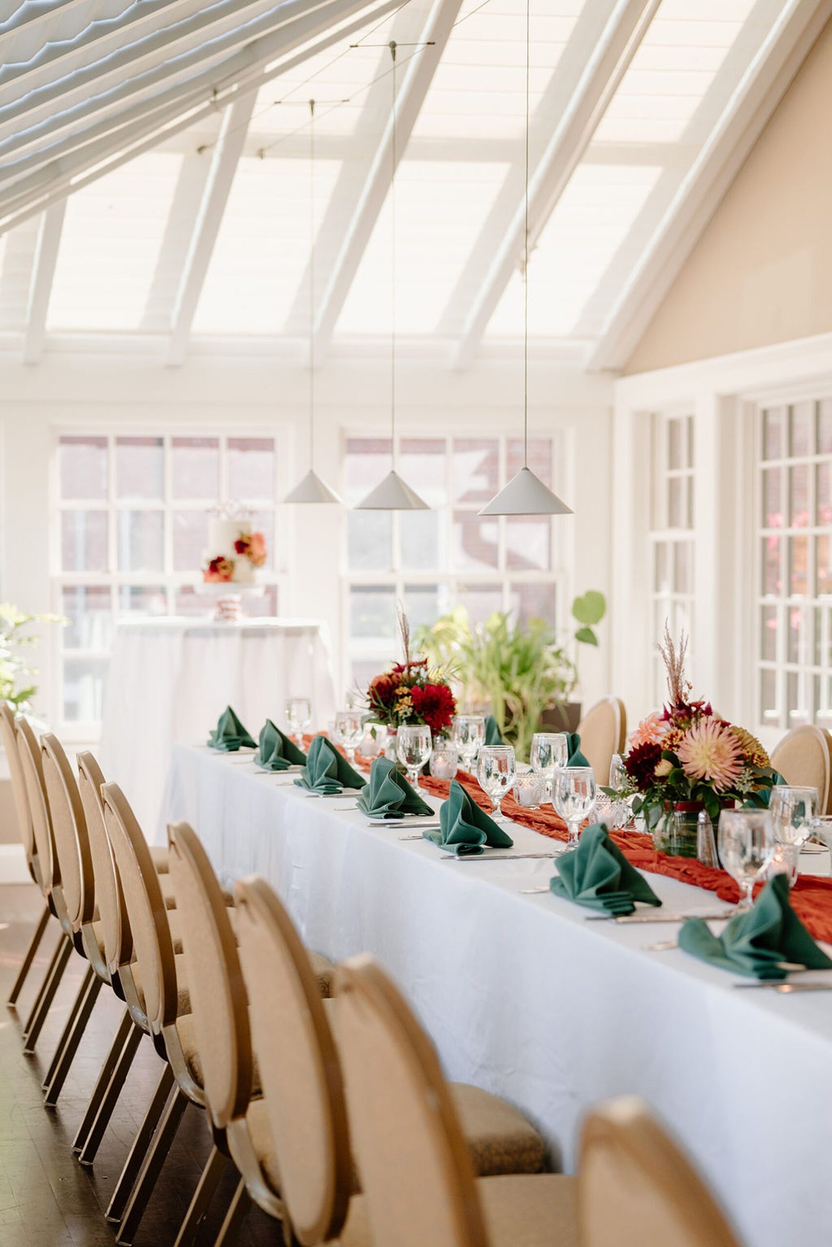 Inn a Boltwood table settings and chairs with light fixtures overhead. 