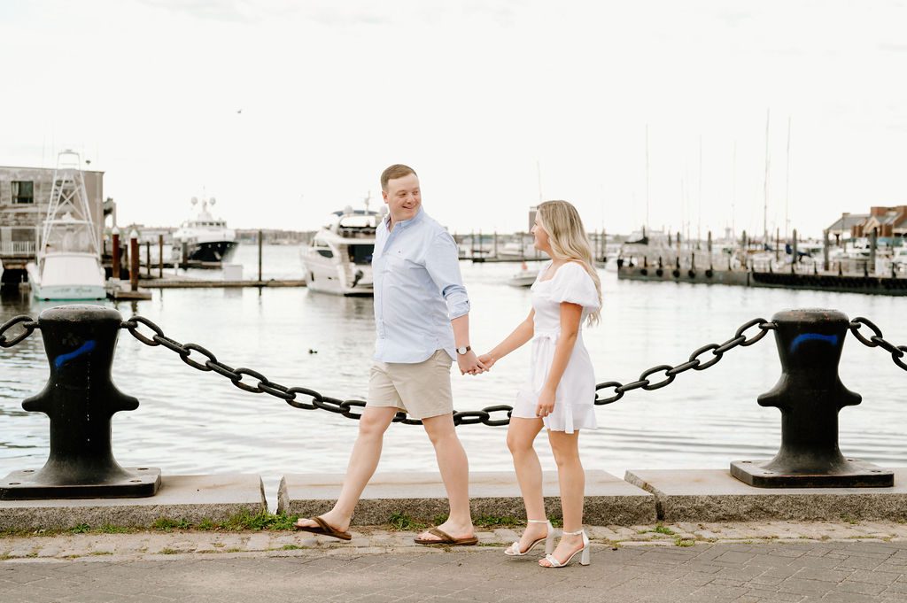 Couple walking hand in hand by Boston Harbor