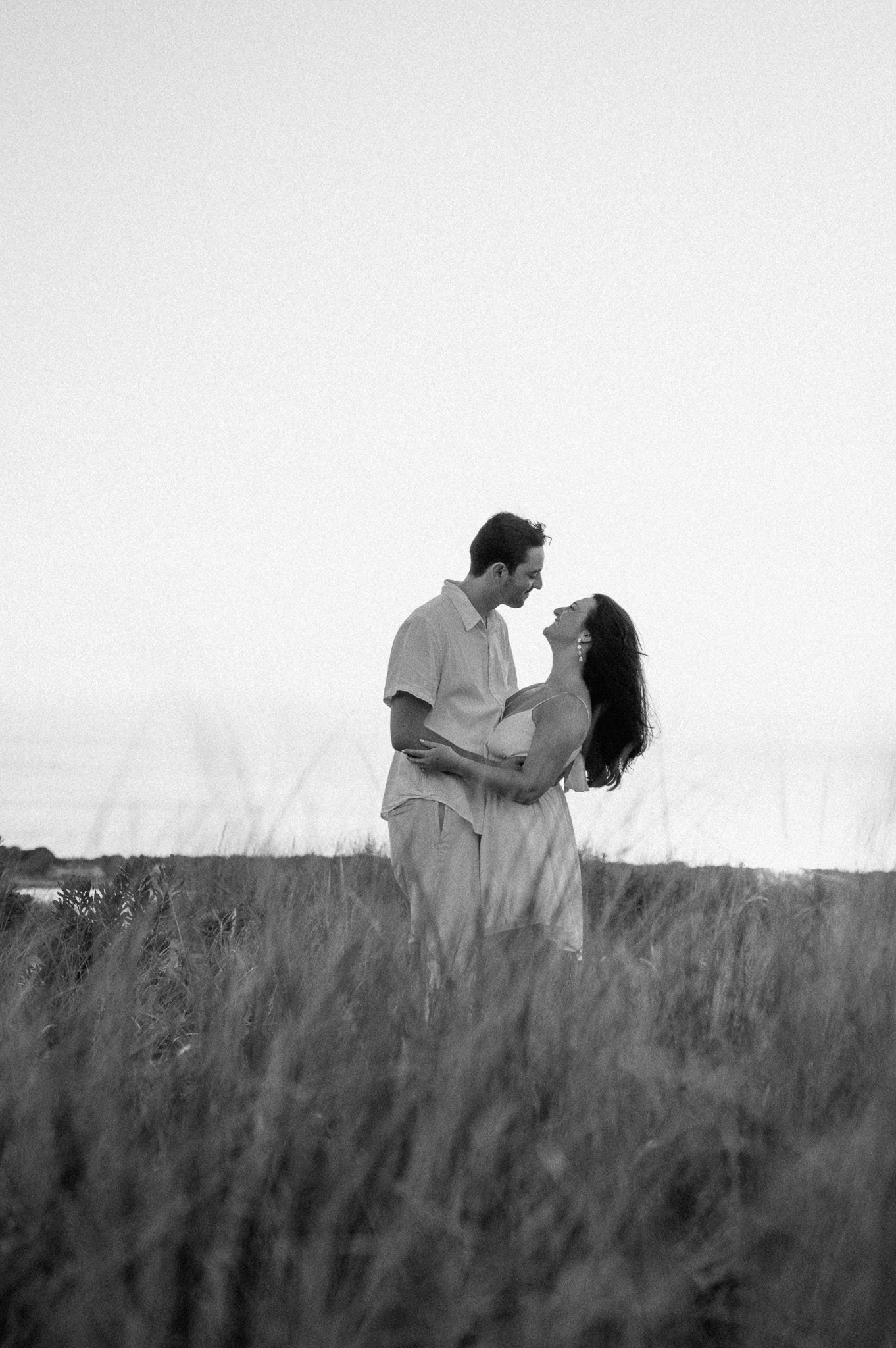 a couple holding each other in the grass.