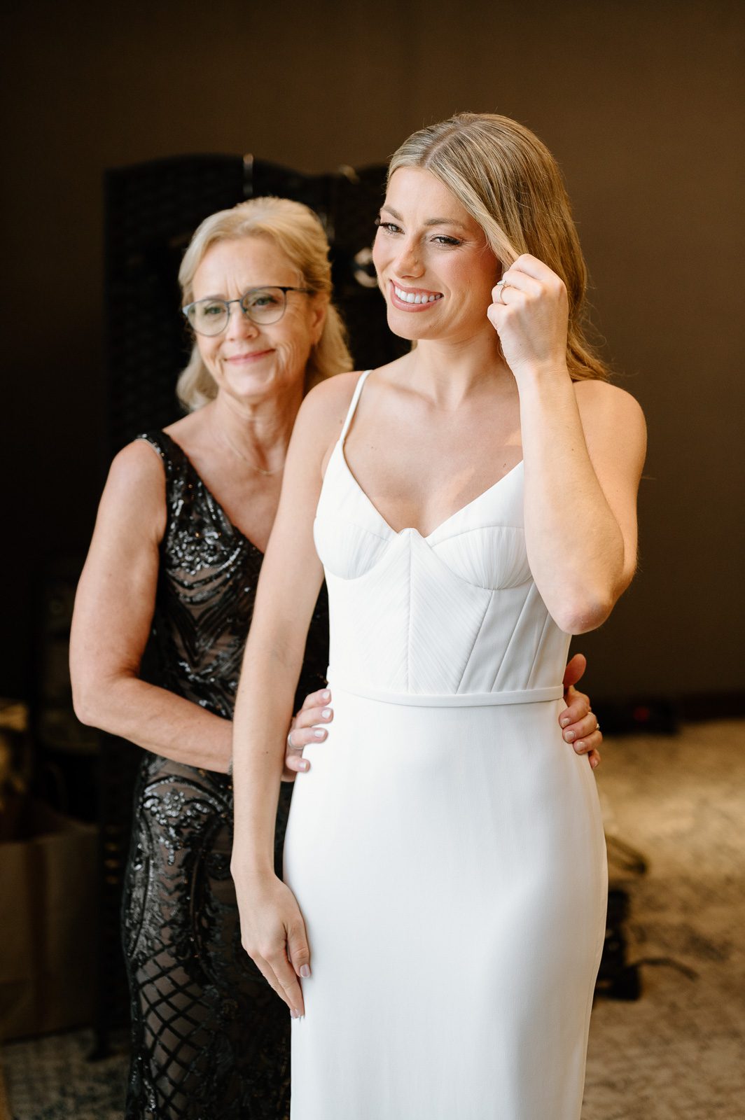 the bride and her mom admiring her dress before her ceremony.