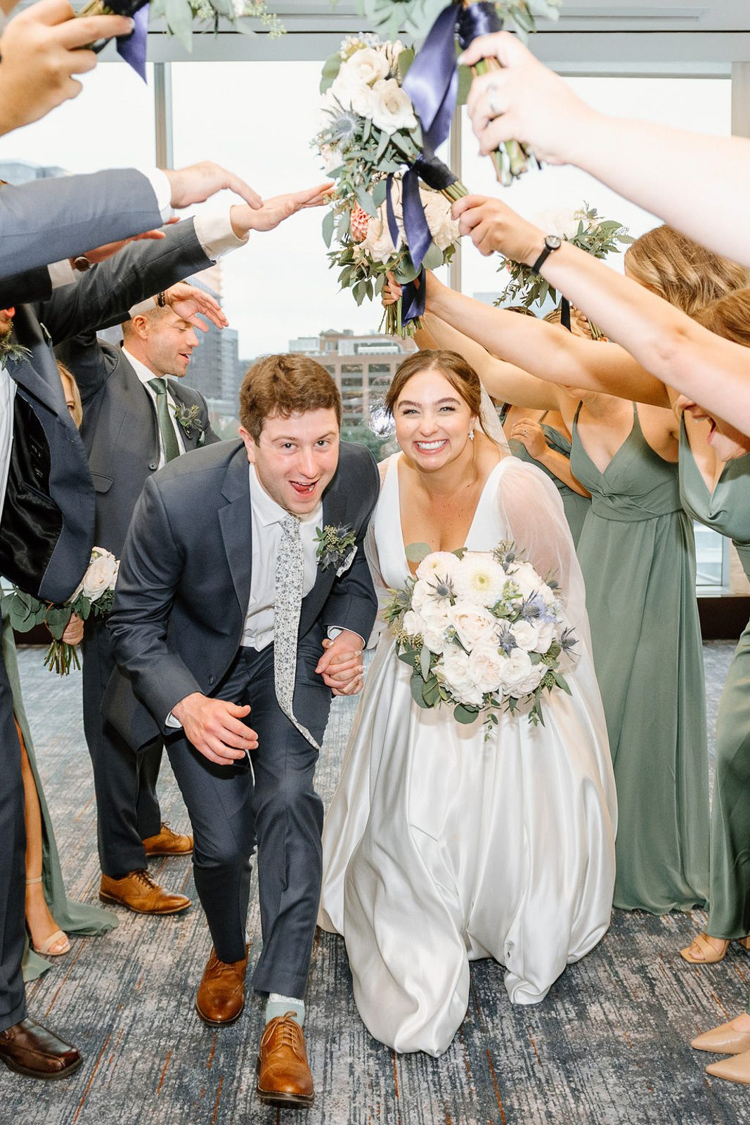 newlyweds under a human tunnel that their wedding party made for them. 