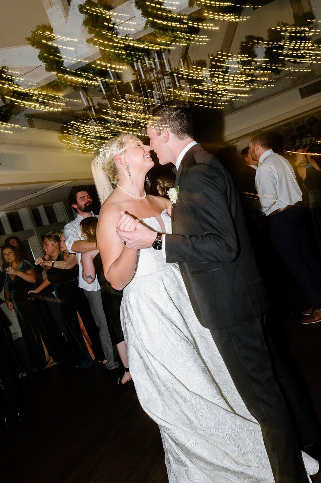 newlyyeds dancing with lights glowing above them during their New England winter wedding. 