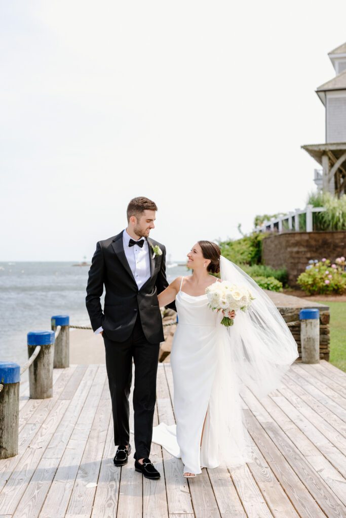 Couple walking during portraits at Wychmere Beach Club.