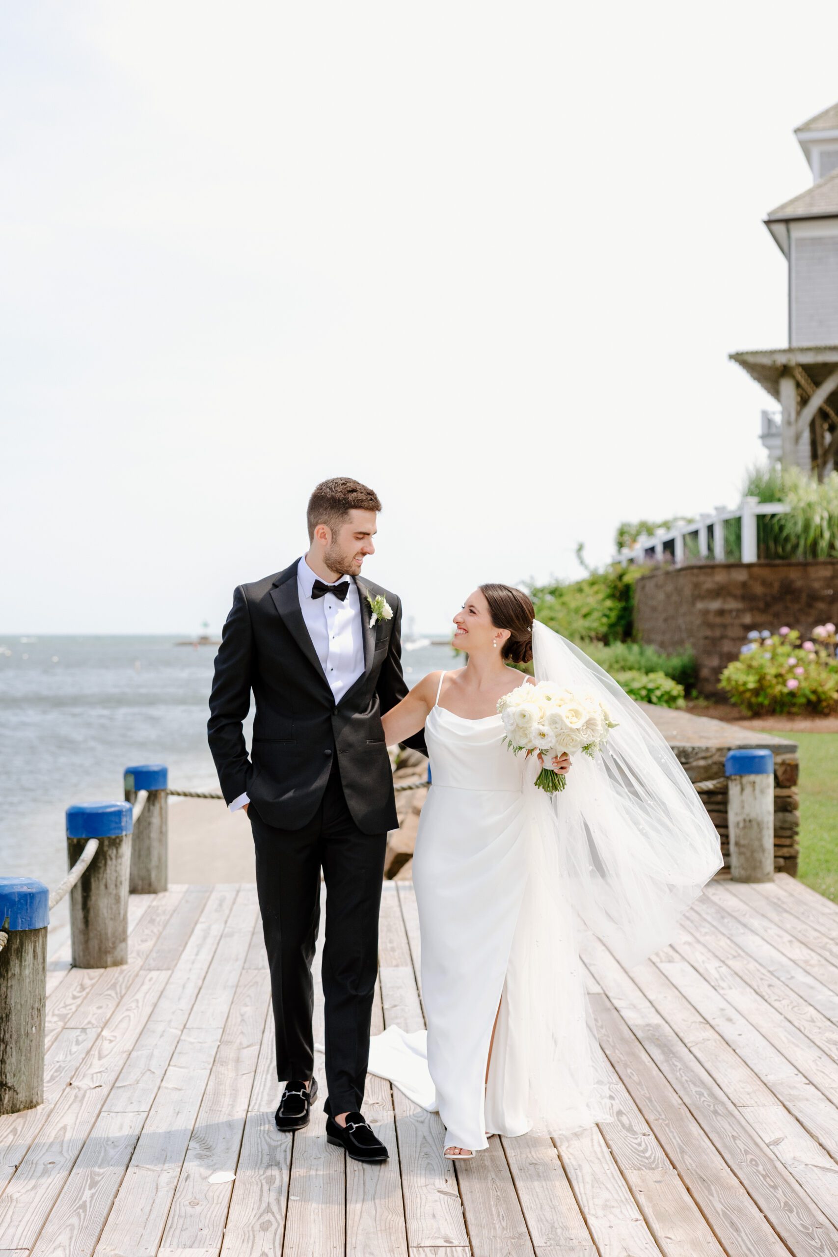 Couple walking during portraits at Wychmere Beach Club.