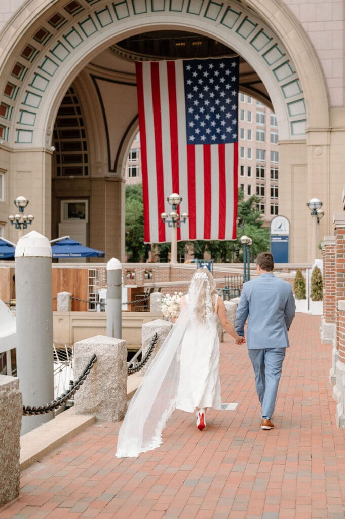 Couple walking by Boston Harbor Hotel